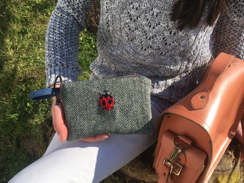 young woman with ladybug embroidered tweed pouch